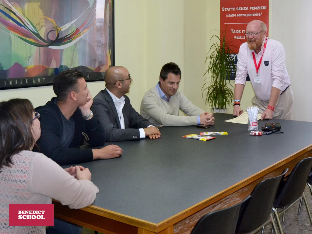 Una lezione Benedict School for Business: adulti attorno a un tavolo con la docente.